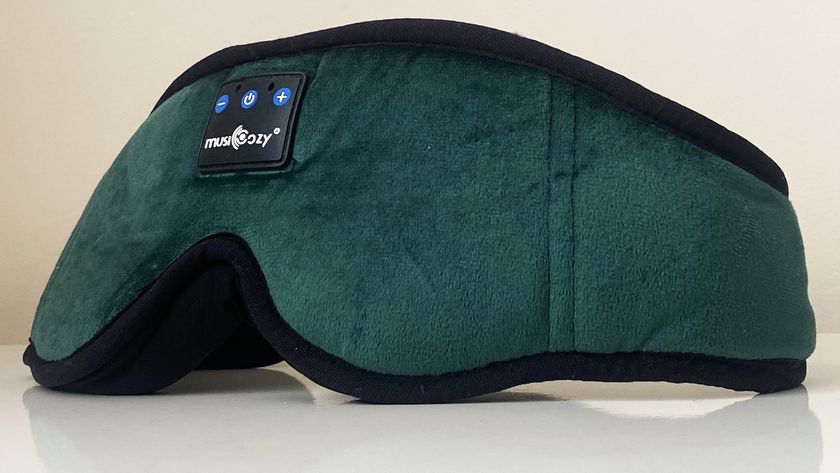 A closeup of the MUSICOZY Bluetooth Sleep Headphones Eye Mask in green on a white surface against a white background