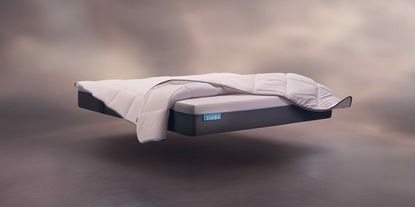 the Simba Hybrid Pro mattress floating on an abstract background with a duvet over it