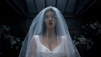 Camila Morrone as Rachel Harkin walking in a wedding dress and veil in Something Very Bad Is Going to Happen