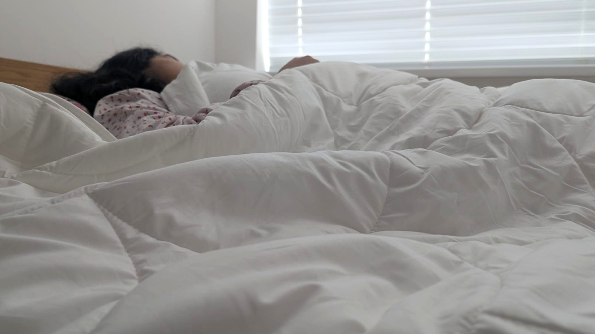 Woman sleeping on her back with the Larke Nature's Blend duvet draped over her