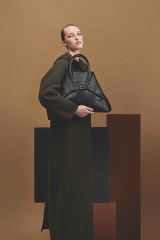 Model in Akris A/W 2024 holds Akris AI bag