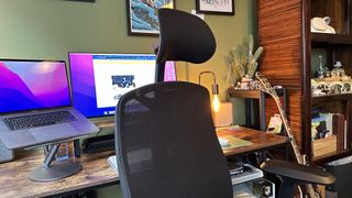 The Herman Miller x Logitech G Vantum gaming chair in a bedroom office with wooden floor and desk.
