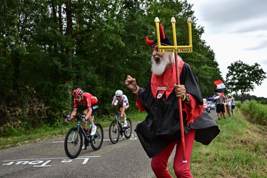 Didi Senft a cycling enthusiast better known as El Diablo The Devil cheers along the roadside as AG2R Citroen Teams French rider Benoit Cosnefroy C and Team Arkea Samsics French rider Anthony Delaplace L cycle in a breakaway during the 4th stage of the 110th edition of the Tour de France cycling race 182 km between Dax and Nogaro in southwestern France on July 4 2023 Photo by Marco BERTORELLO AFP Photo by MARCO BERTORELLOAFP via Getty Images