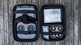 Emax Tinyhawk III Plus FPV Racing Drone RTF in a carry case with accessories on wooden slatted decking