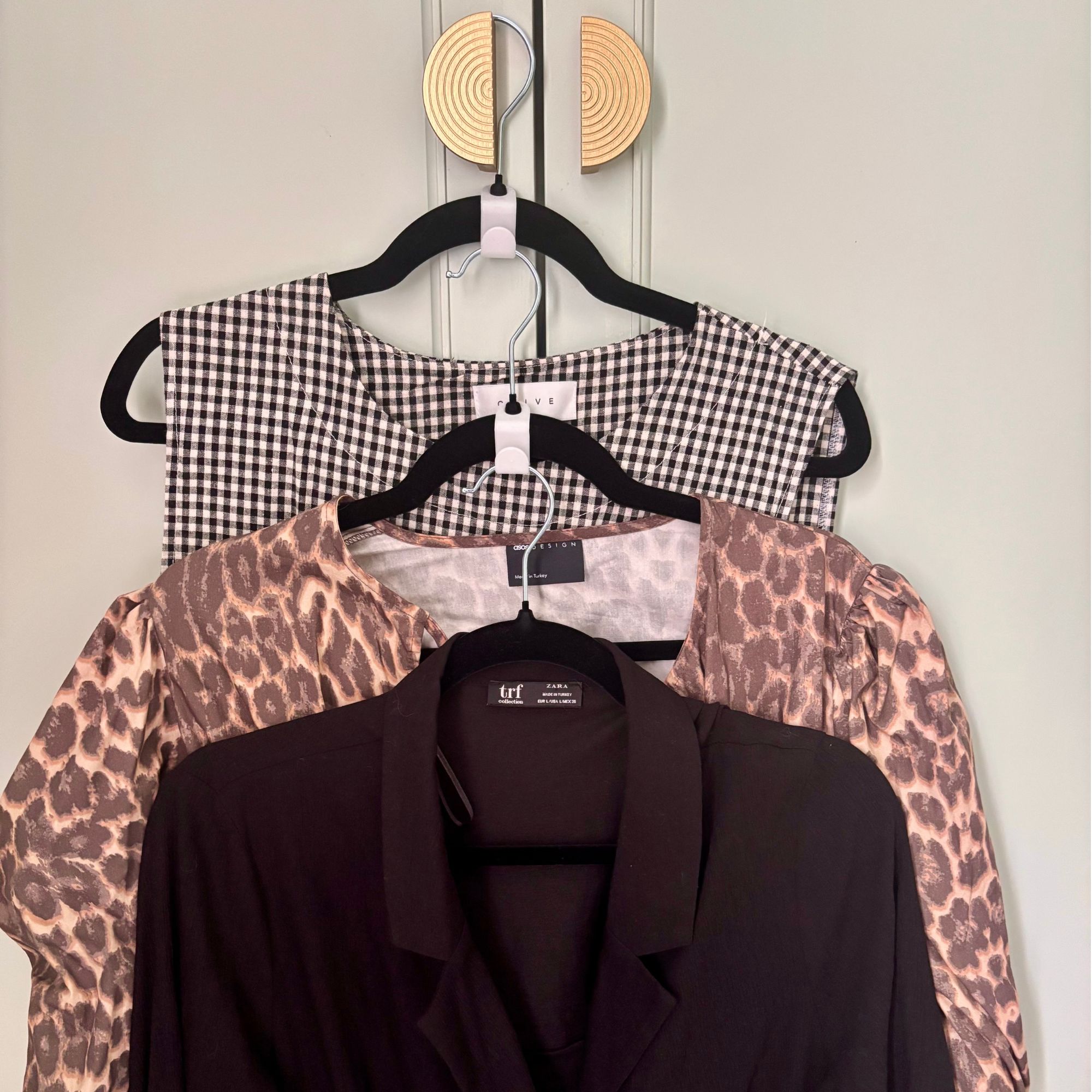 Wardrobe door with clothes hangers and shirts hanging off the door knob
