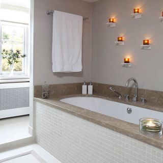 master en suite bathroom with shelves for tealight candles and bathtub