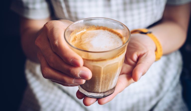 Woman holding a milky latte