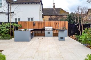 how to design an outdoor kitchen: modern design with timber backdrop