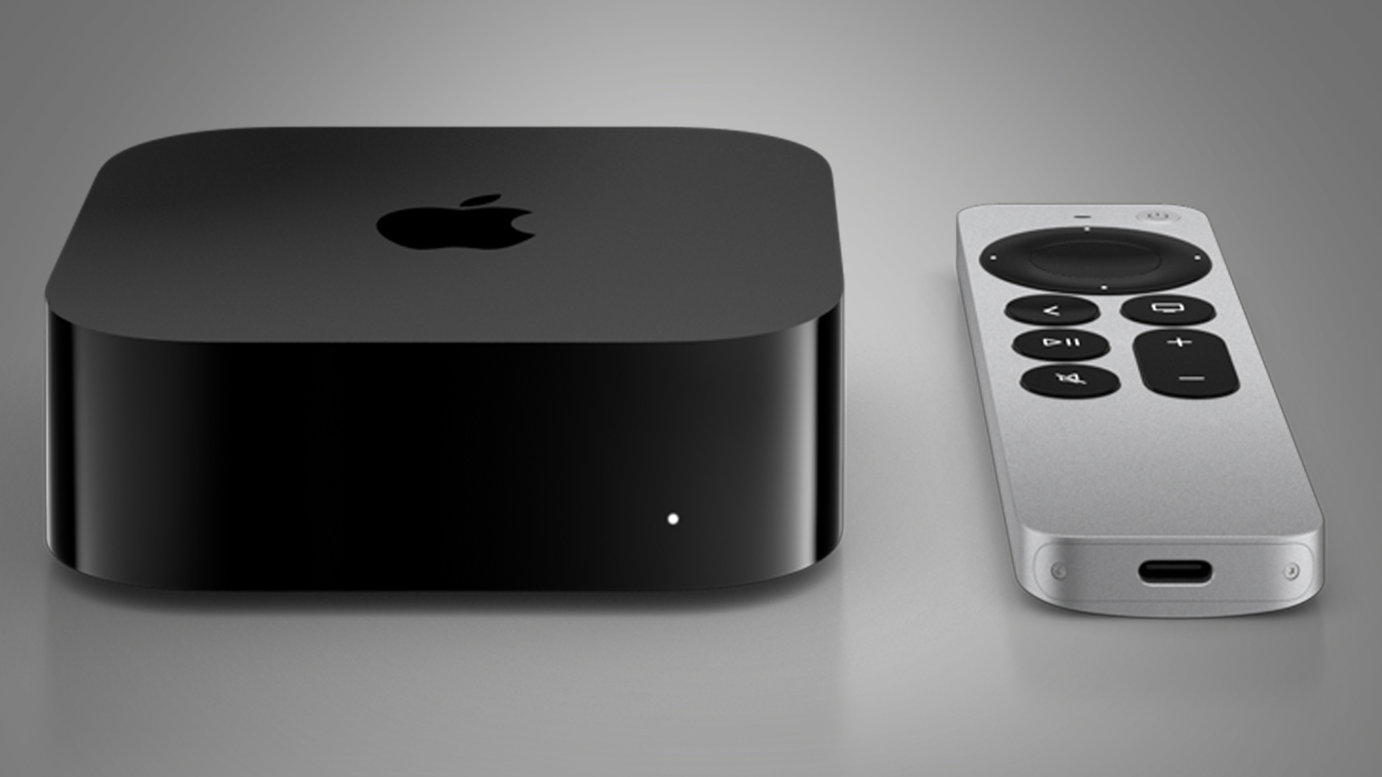 The Apple TV 4K 2022 with its remote on a grey background