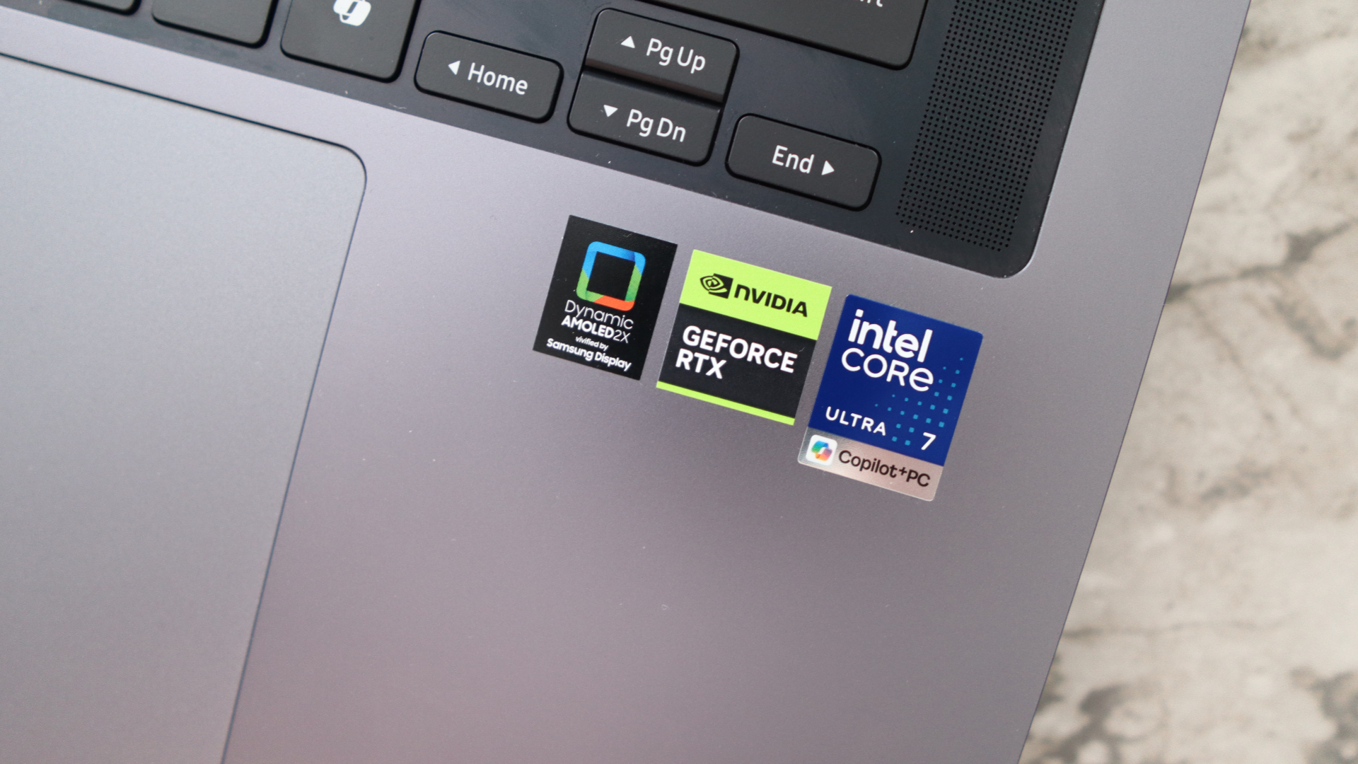 A close-up of stickers on a laptop. Both Intel Core Ultra 7 and Geforce RTX stickers are visible.