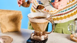 the clever dripper, a brown transparent plastic manual coffee maker with a handle and a sluice feature in the bottom to keep water inside