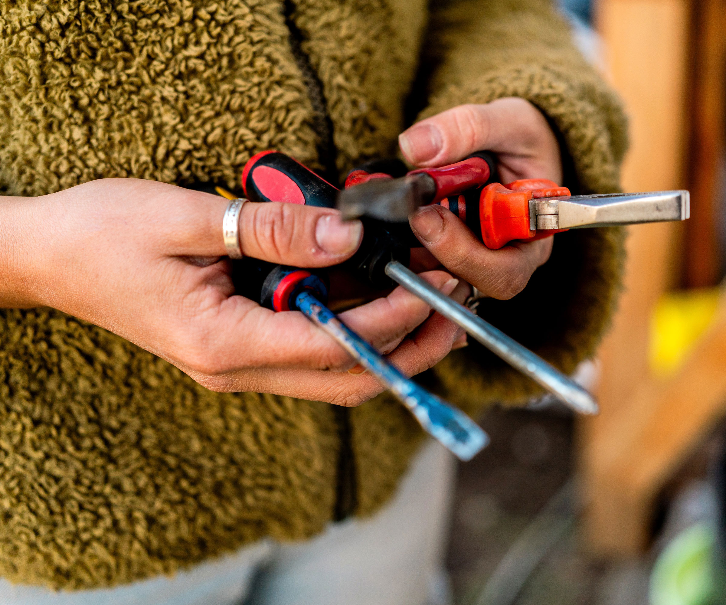 woman holding work tools including screwdriver