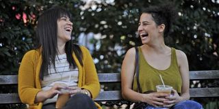 Abbi and Ilana laughing on a bench