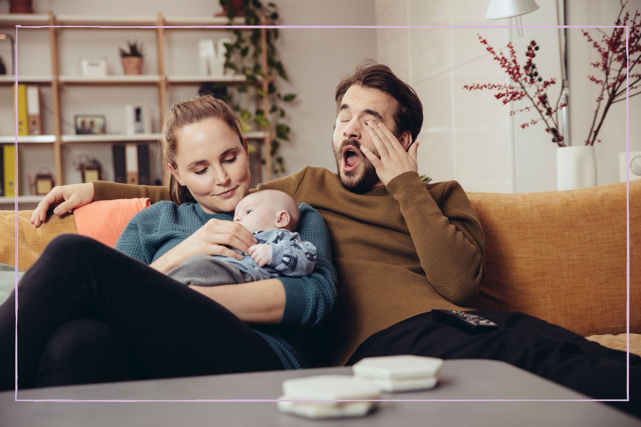 Tired parents on the sofa with dad yawning