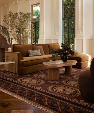 chocolate and toffee colored living room with velvet couch and large rug