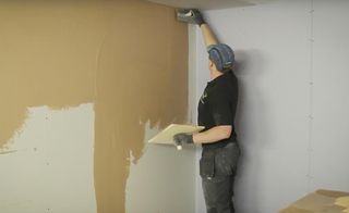 Man skimming plasterboard walls