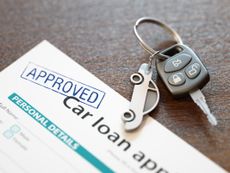 Car loan paperwork with car keys next to it
