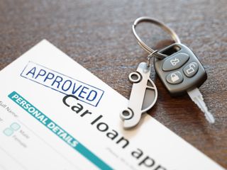 Car loan paperwork with car keys next to it