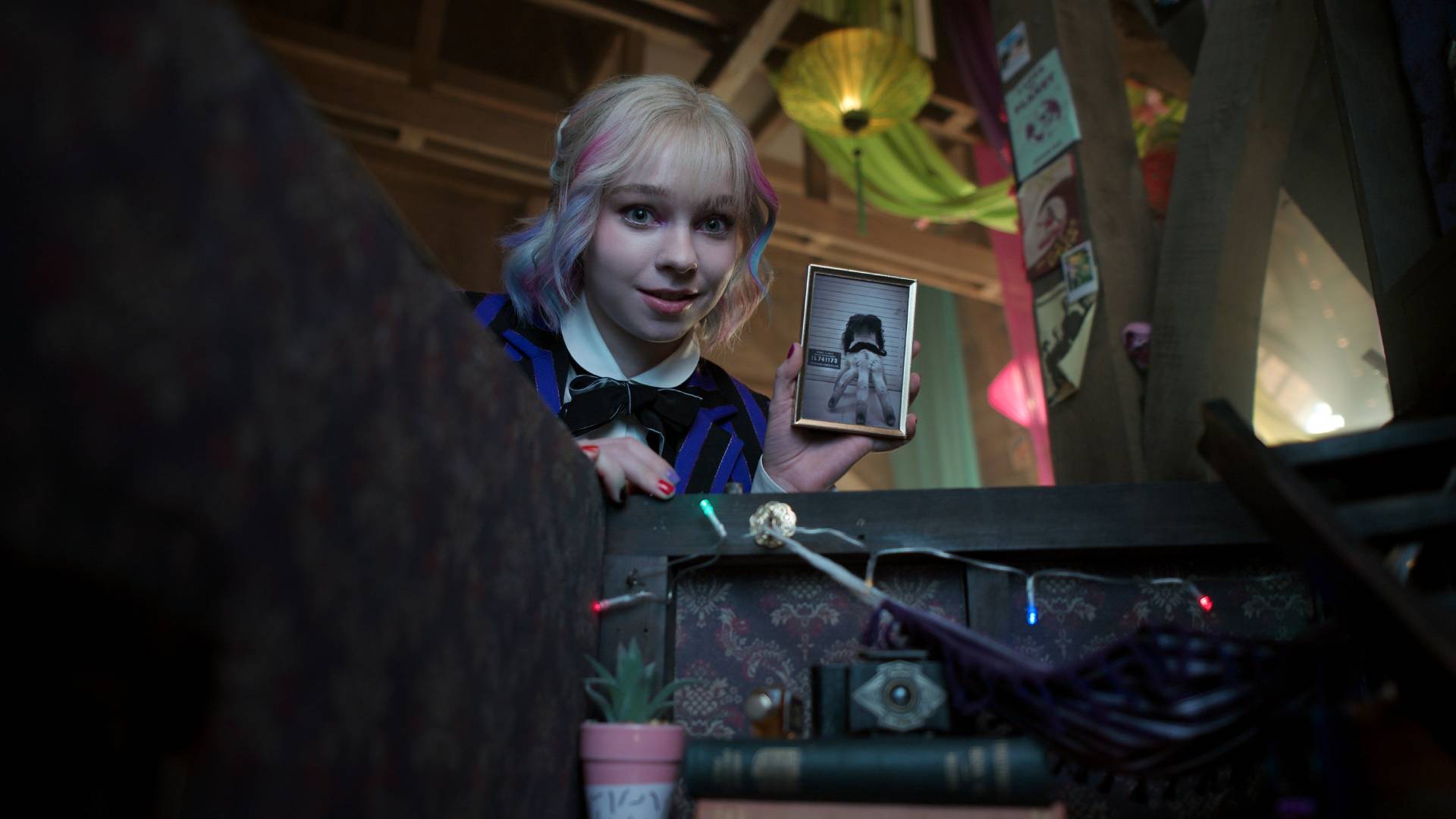 Enid (Emma Myers) holds up a picture of Thing in Wednesday season 2 part 1