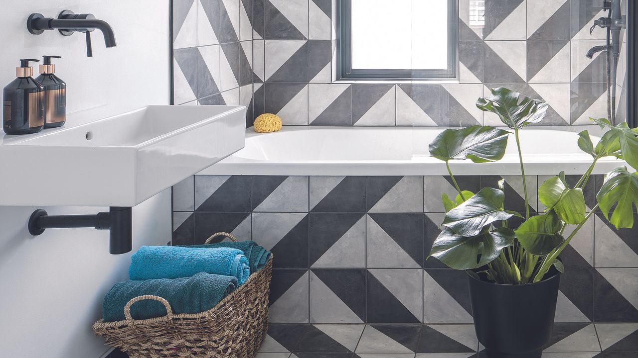 Black and white bathroom with geometric tiles and plant