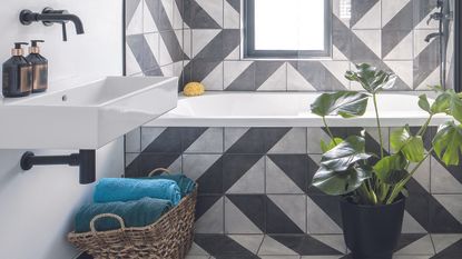 Black and white bathroom with geometric tiles and plant