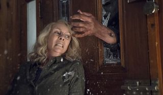 Halloween Jamie Lee Curtis trembles under Michael Myers' hand, bursting through the glass