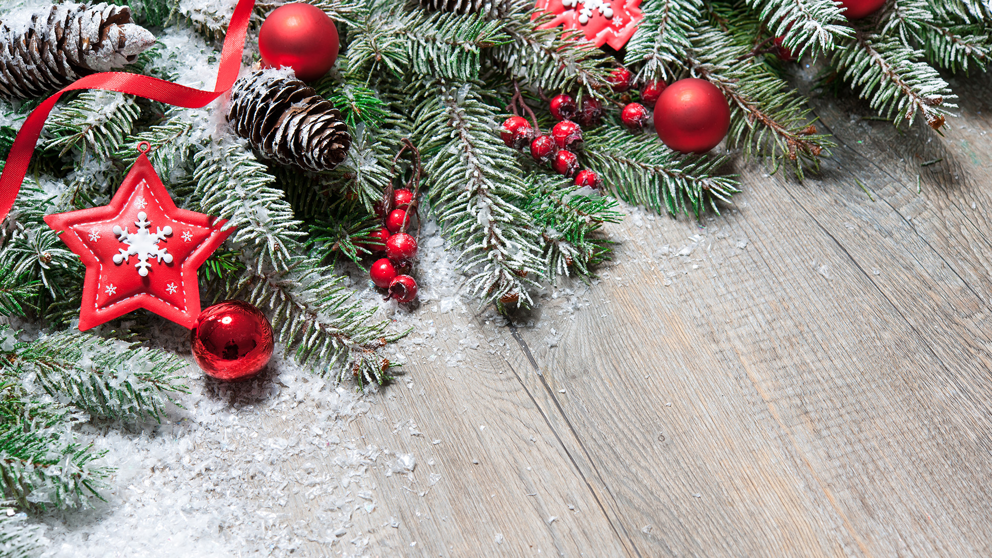 Artificial snow on Christmas tree branches on wooden flooring