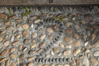 DIY door number made from pebbles on the floor