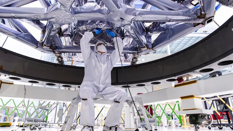 A team member works underneath the Instrument Carrier for Roman during the integration of the Coronagraph in a clean room at NASA Goddard in October 2024. (Image credit: NASA/Sydney Rohde)