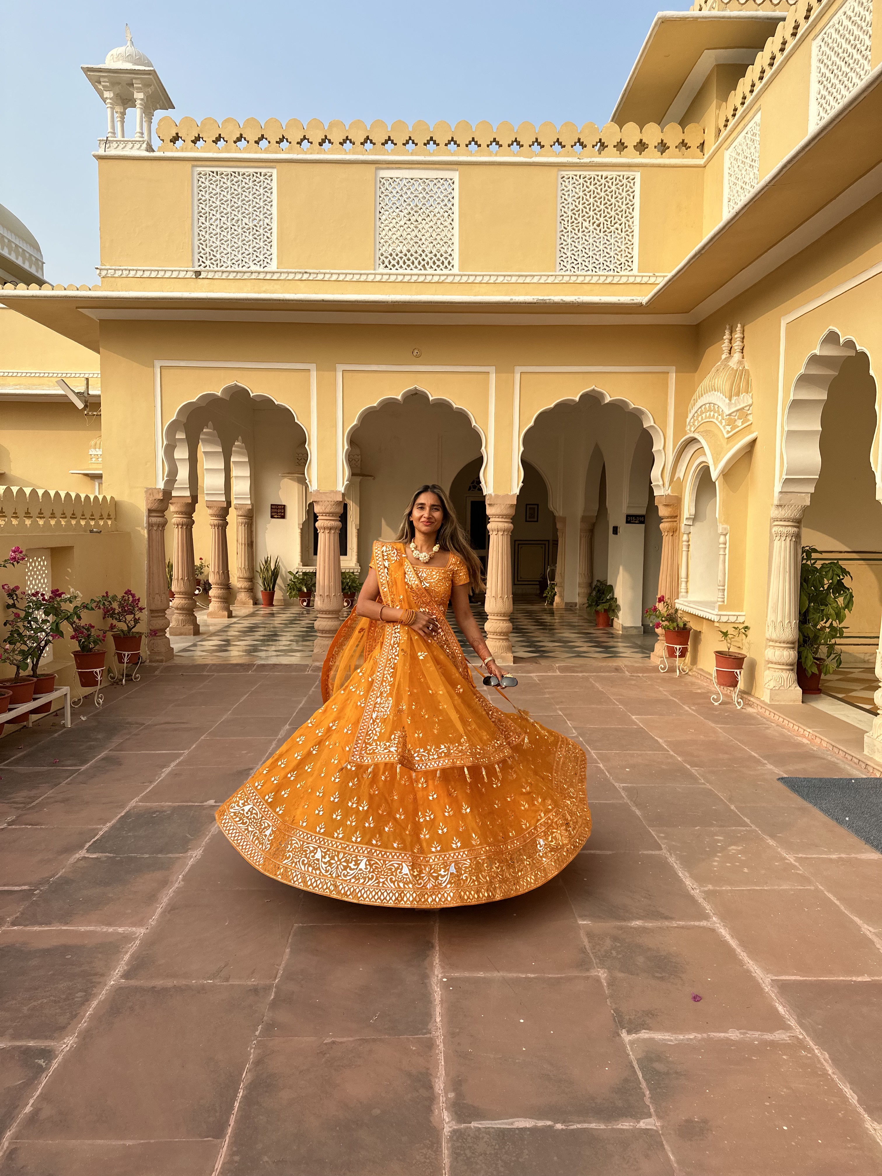 @arentyoueshita wears an orange and gold Indian wedding guest outfit