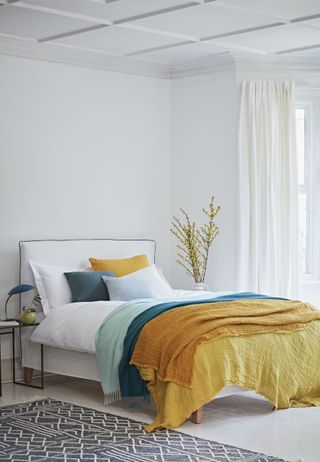 White bedroom with colorful cushions