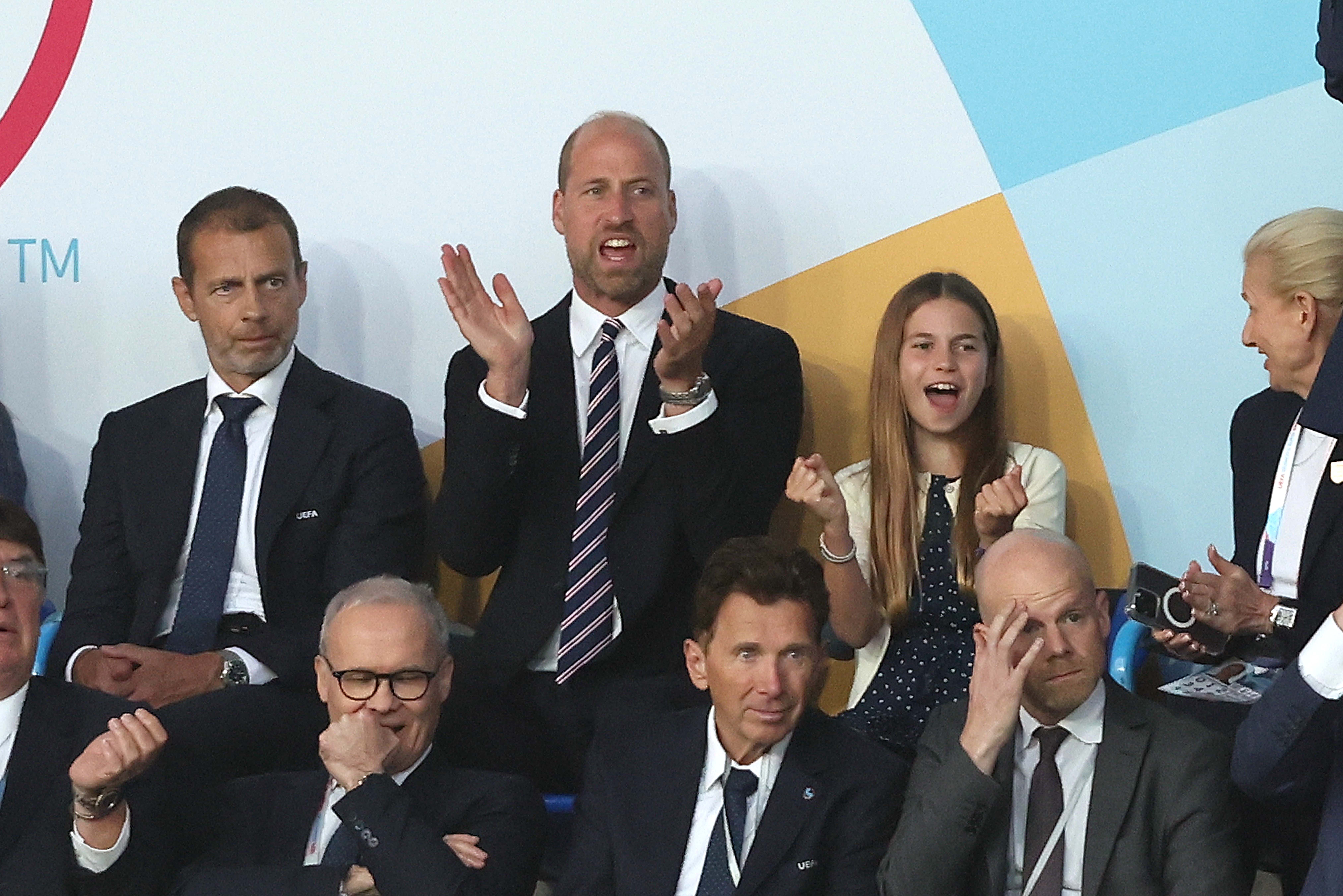 Prince William and Princess Charlotte clapping at a soccer game