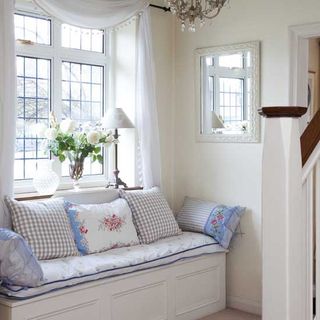hall with white wall and sitting area with cushions