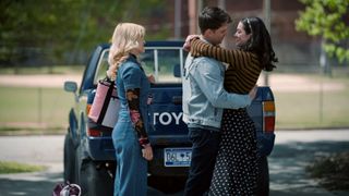 Tommi Rose as Olivia Harris, Carson Rowland as Tyler Townsend and Anneliese Judge as Annie Sullivan as ty and annie hug outside of a truck by a baseball field in sweet magnolias season 4