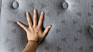 Our reviewer's hand resting on the surface of the Zoma Boost mattress