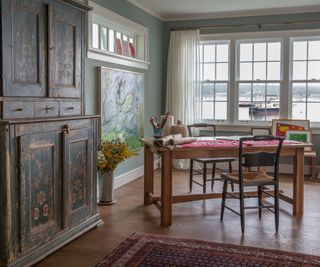 art room with folk art cabinet and view of old boats through window