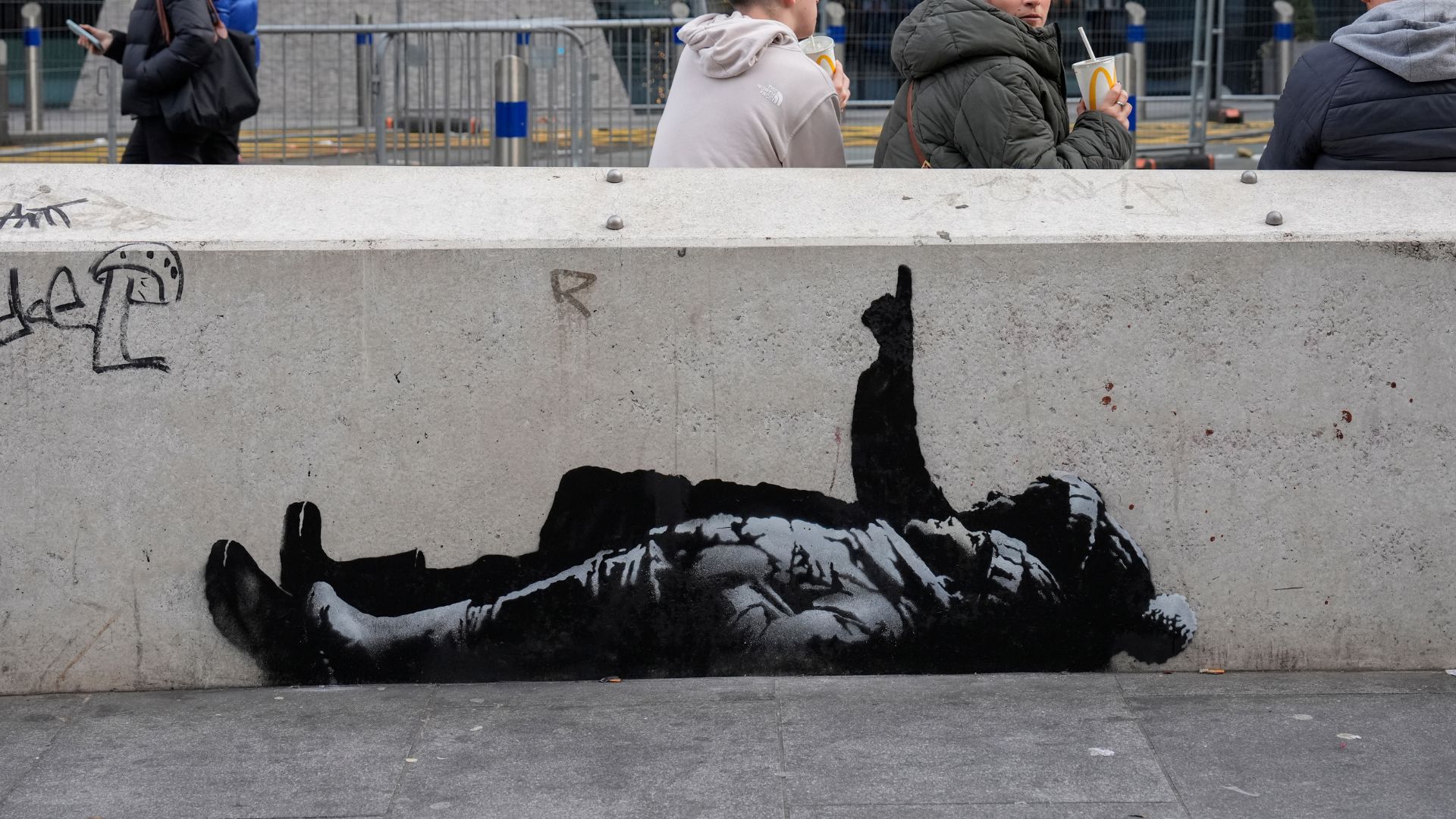 Pedestrians walk past a mural on the side of a wall, alleged by local media to have been created by street artist Banksy, in the Tottenham Court Road area of central London on December 22, 2025. (Photo by CARLOS JASSO / AFP via Getty Images)