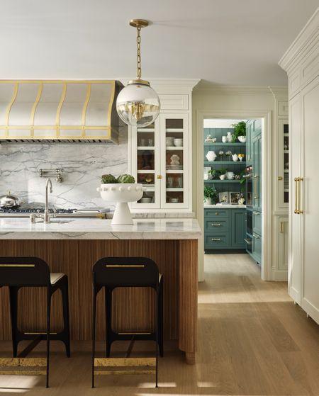 reeded island with steel cooker hood and blue-green pantry 