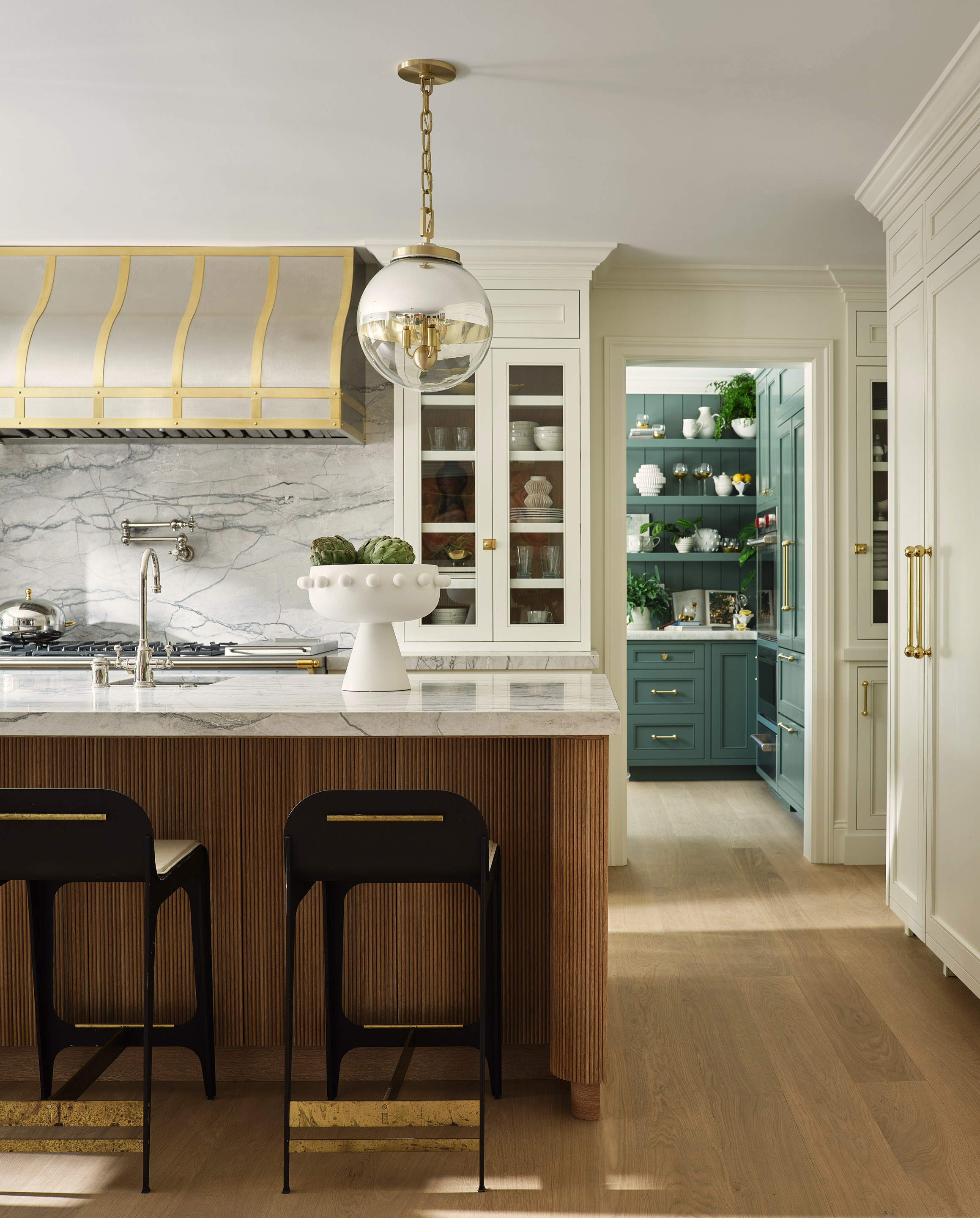 reeded island with steel cooker hood and blue-green pantry