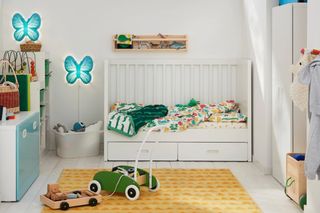 White nursery ideas with playful, colorful accessories including butterfly wall lights and bed linen.