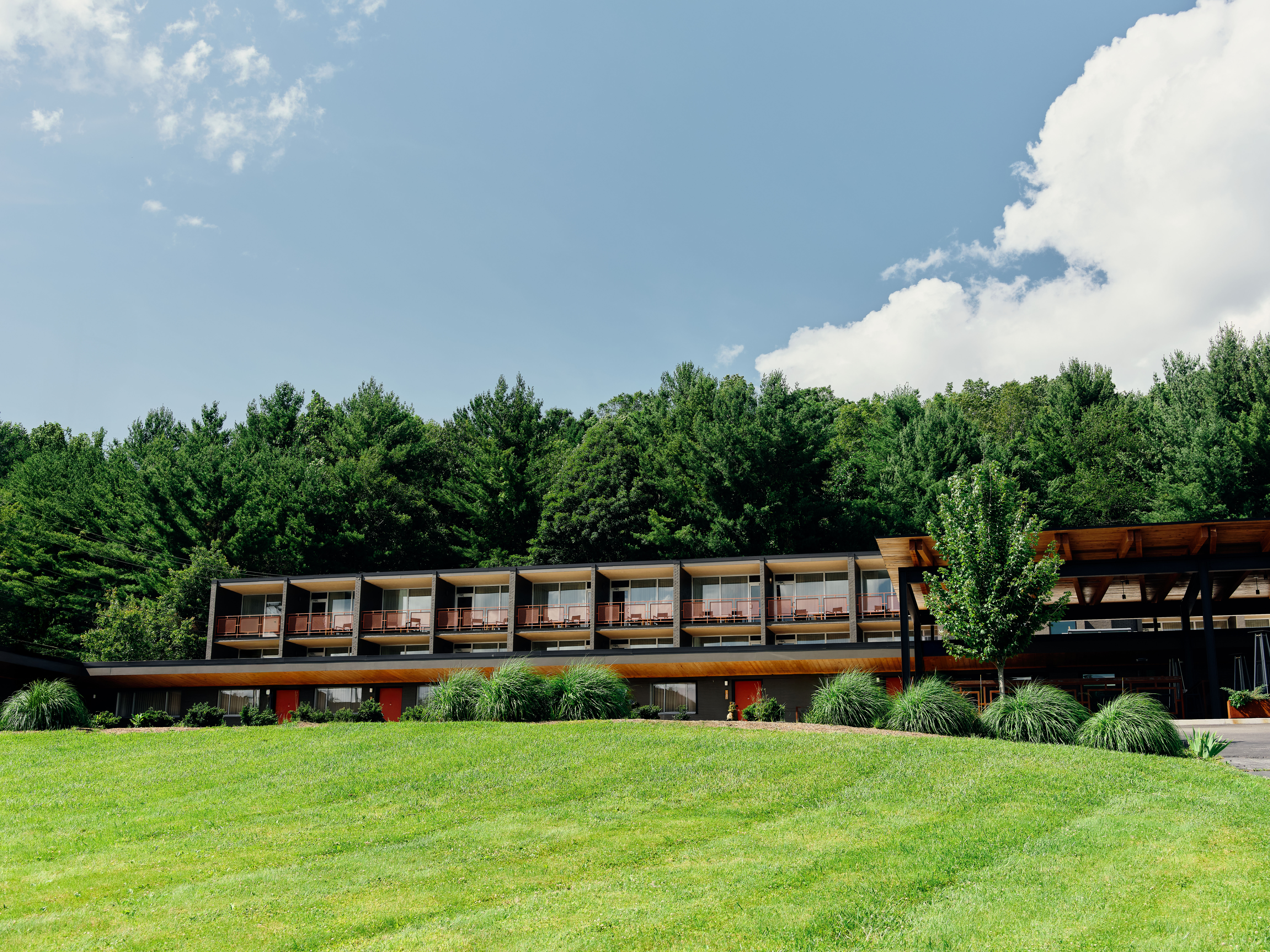 The exterior of the Rhode&#039;s Motor Lodge behind a green lawn