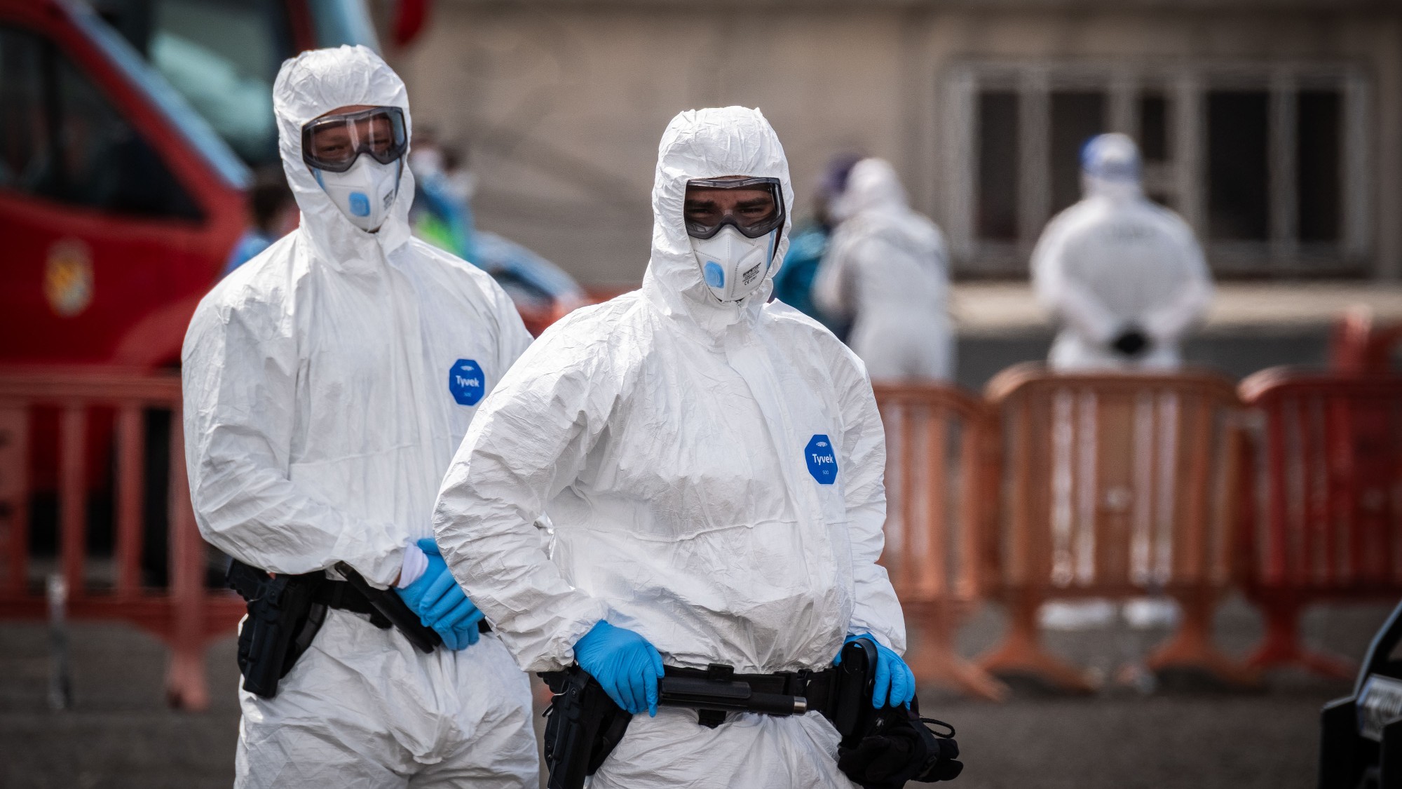 Two people in hazmat suits evacuating the hantavirus cruise ship