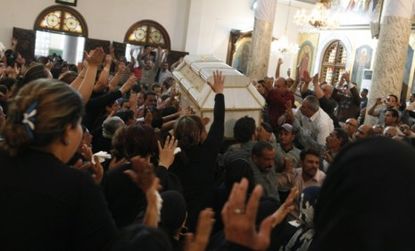 Coptic Christians chant pro-Christian slogans during the funeral for victims of Saturday's religious clashes in Cairo, Egypt, that killed 12