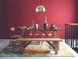 dining room with dark red walls and wooden dining set by habitat