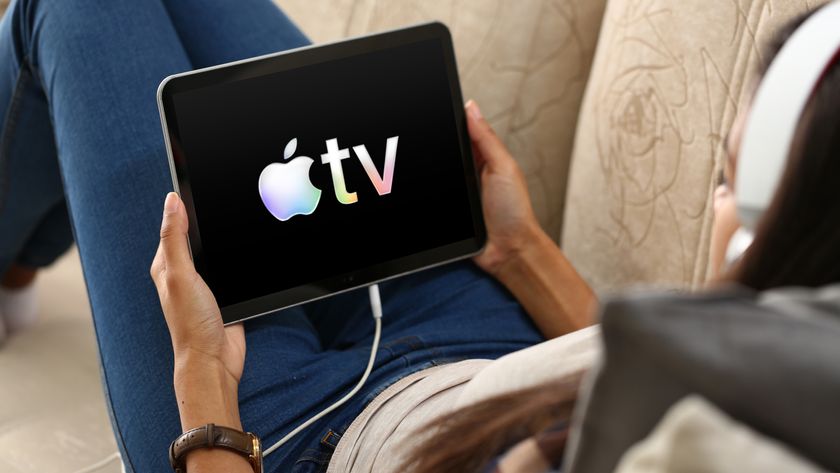 The Apple TV logo on an iPad that someone&#039;s holding while sat on a couch