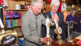 Prince Charles pulling a pint in a pub