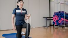 Woman using resistance band to exercise in gym