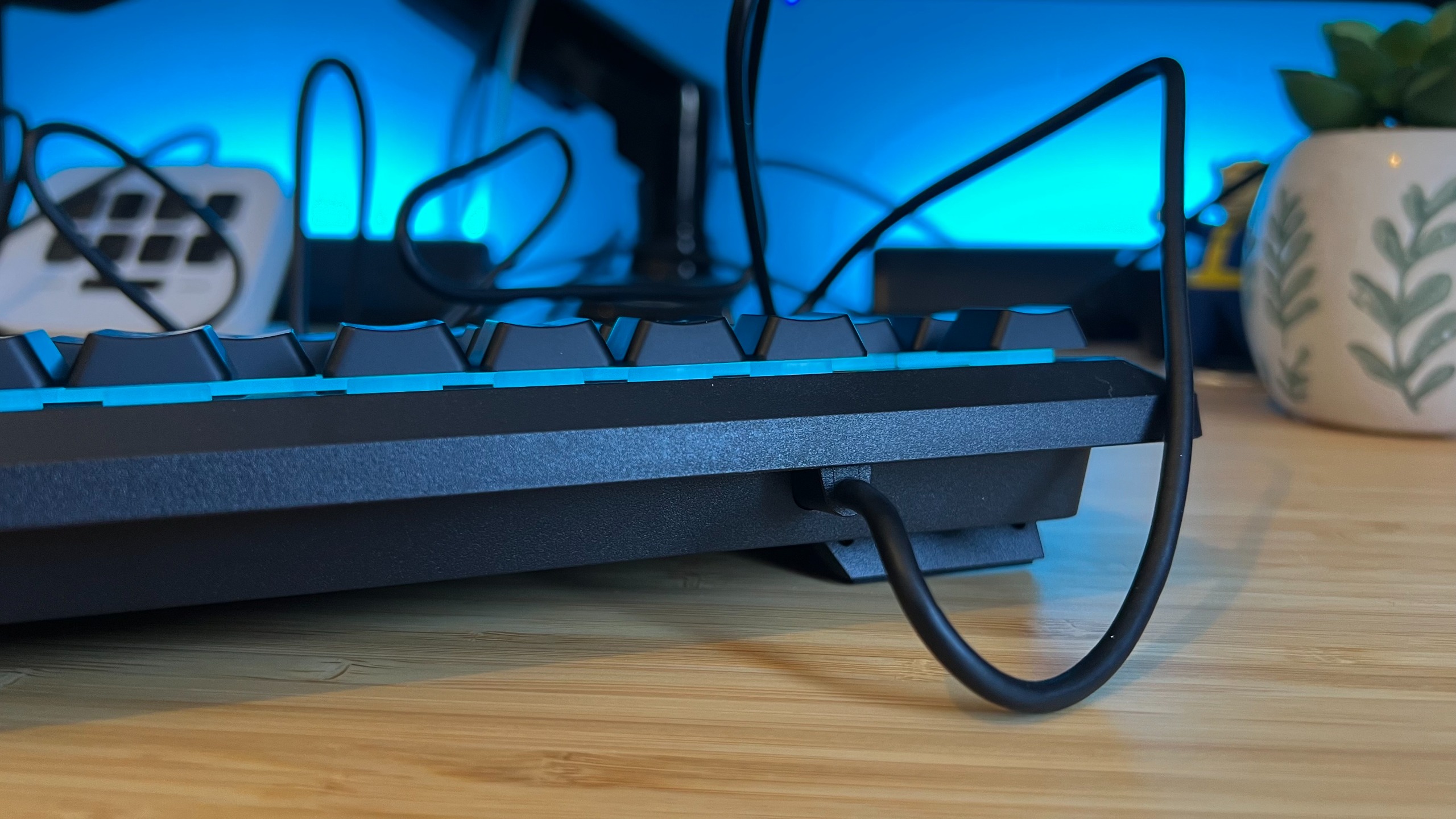 Rear side of top lip on Corsair Skiff 100 Plus gaming keyboard, showing USB-A cable hardwired into chassis