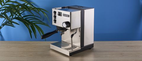 Rancilio Silvia in Stainless steel on a wooden worktop with a blue wall in the background.