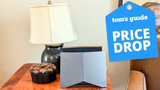 The TP-Link Archer GE800 on a table with a Tom&#039;s Guide Price Drop deals badge